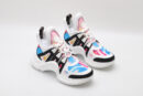 A pair of white chunky athletic sneakers with vibrant pink and blue swirl graphics, bold black structural overlays, white laces, a thick white sculptural sole, and mint green accents on the outsole, displayed against a plain white background.