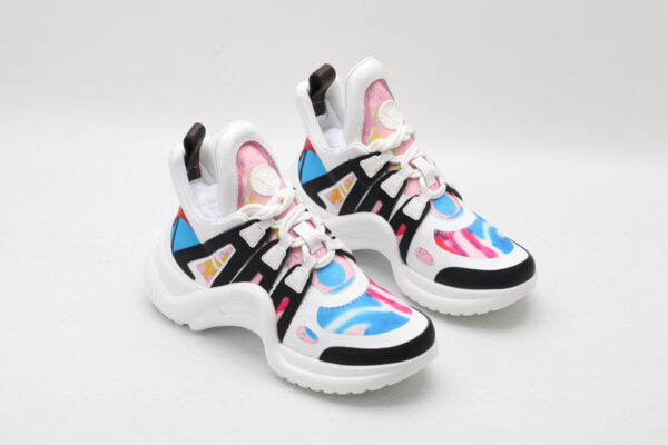 A pair of white chunky athletic sneakers with vibrant pink and blue swirl graphics, bold black structural overlays, white laces, a thick white sculptural sole, and mint green accents on the outsole, displayed against a plain white background.