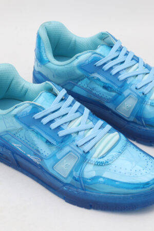 A pair of vibrant translucent blue low-top sneakers with matching laces and a clear blue sole, displayed against a clean white background.