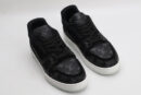 A pair of Louis Vuitton LV Trainer sneakers in black and grey monogram, featuring a white midsole and translucent outsole