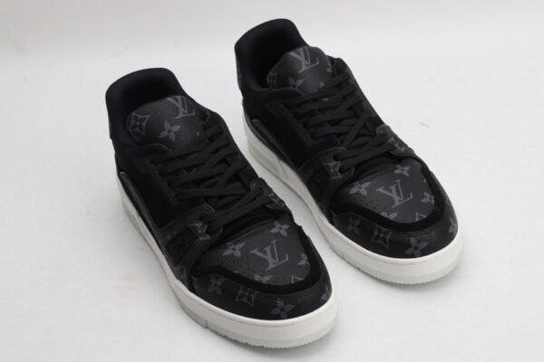 A pair of Louis Vuitton LV Trainer sneakers in black and grey monogram, featuring a white midsole and translucent outsole