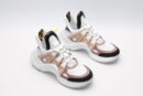 A pair of white chunky athletic sneakers with beige and light brown overlays, white laces, black accents on the toe and heel, and a large, sculpted white sole, displayed against a light grey background.