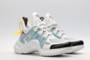 A pair of white, light blue, and black multi-panel chunky sneakers with a thick white sole, red and yellow accents, and a distinctive brown logo tag. The sneakers are photographed on a clean white background from a slightly elevated side angle.