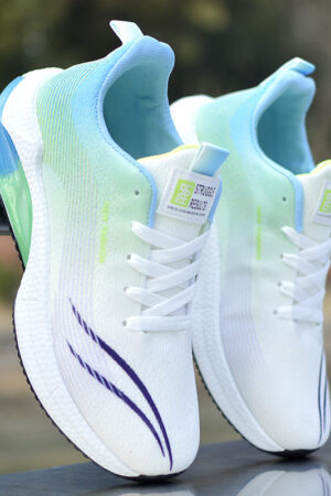 A pair of sleek unisex athletic sneakers with a colorful gradient pattern and a semi-translucent cushioned sole