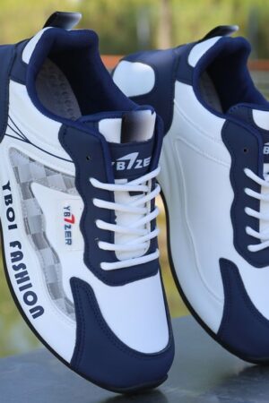 A pair of white and blue unisex sneakers with black accents and a cushioned sole, shown leaning against a wall.