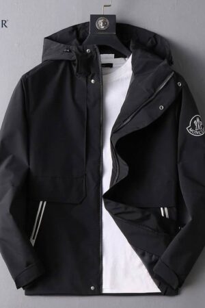 Black Moncler hooded jacket with a large white Moncler logo and lettering printed on the back. Features a round logo patch on the sleeve.