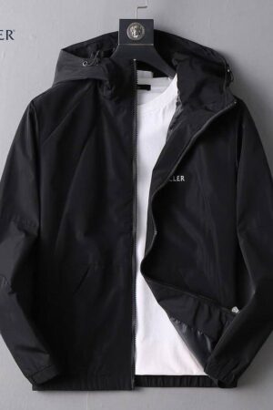 Black nylon Moncler hooded jacket with white logo tape repeating vertically along the main zipper and surrounding the hood's edge.