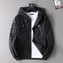 Black Moncler hooded nylon windbreaker jacket with a large, dark gray or black tonal Moncler logo print diagonally down the left sleeve