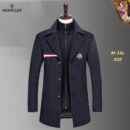 Brown or tan wool-blend Moncler long overcoat with a zip-in mock-neck knit inner layer, tricolor trim on the chest pocket, and a Moncler logo patch on the lapel