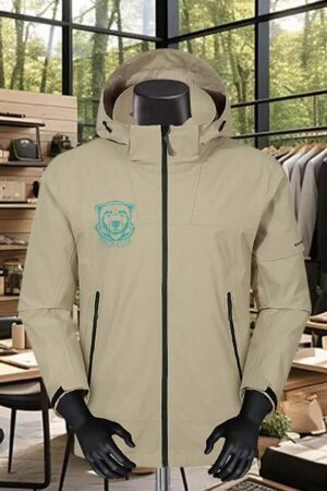 A heavy-duty, sand-colored performance parka with a black full-zip front and a large hood, featuring a turquoise bear graphic on the chest.