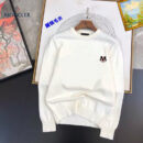 A pristine white crewneck sweater featuring a small designer-style logo on the chest, displayed on a flat surface with artistic backgrounds.
