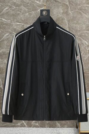 A black high-neck track jacket with white and grey racing stripes on the sleeves and a designer-style logo on the left arm.