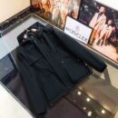 Flat lay view of a heavy-duty black tactical field parka with large cargo pockets and a snap-front closure.