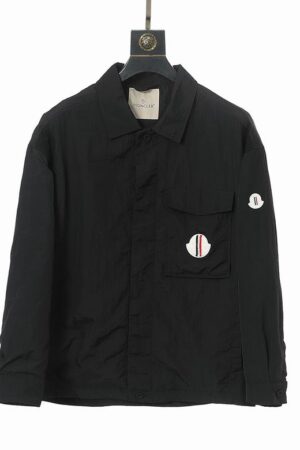 Matte black shirt-jacket with a button-front closure, pointed collar, and signature circular logo patches on the chest and arm.