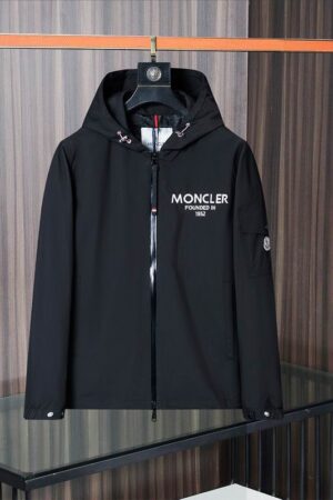 Black Moncler hooded jacket with white logo print on the chest, a utility sleeve pocket, and signature branding.