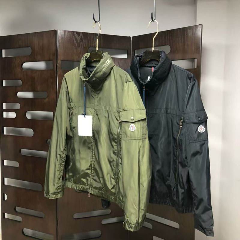 Moncler-style olive green lightweight windbreaker/utility jacket with a high collar, multiple zippered and flap pockets, and a circular logo patch on the left arm pocket.