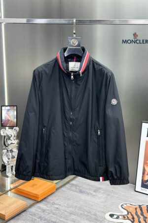 High-quality black Moncler Carles hooded windbreaker with silver zippers and signature logo patch on the sleeve, shown on a clean studio background.