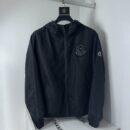 Black Moncler x Fragment collaborative windbreaker with a large circular logo on the chest, adjustable hood, and signature felt logo on the sleeve.