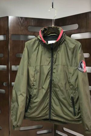 Olive green hooded jacket with a red inner collar trim and a large signature logo patch on the left sleeve.