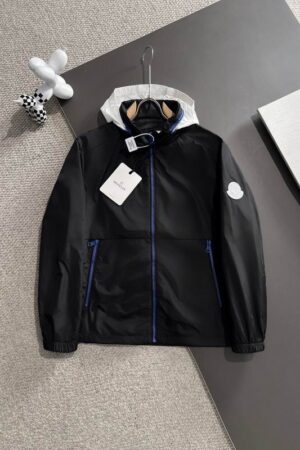 Black lightweight windbreaker jacket with a contrasting white hood and bright blue zippers on the front and pockets.