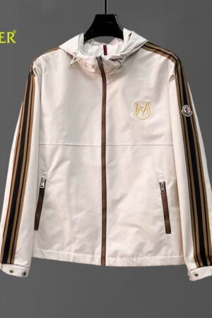 An off-white hooded windbreaker jacket with brown and black athletic stripes running down the sleeves and a gold embroidered logo on the chest.