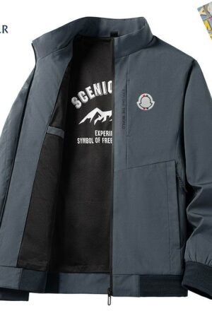 A front view of a men's technical bomber jacket with a stand collar, a vertical zippered chest pocket, and a mountain-themed graphic lining visible on the interior.resistant outerwear, urban techwear, mountain graphic jacket, premium men's shell, tactical fashion, weather-ready coat, water-repellent windbreaker, designer style jacket
